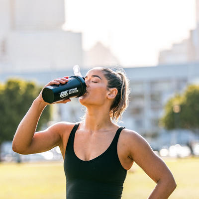 woman drinking from her optimum nutrition shaker